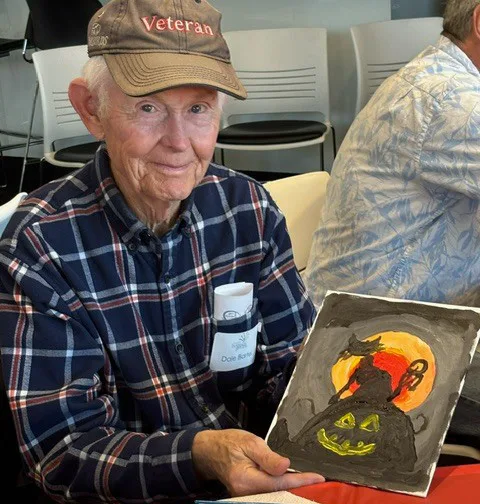 Older adult holding artwork during a community-based care activity in Wisconsin